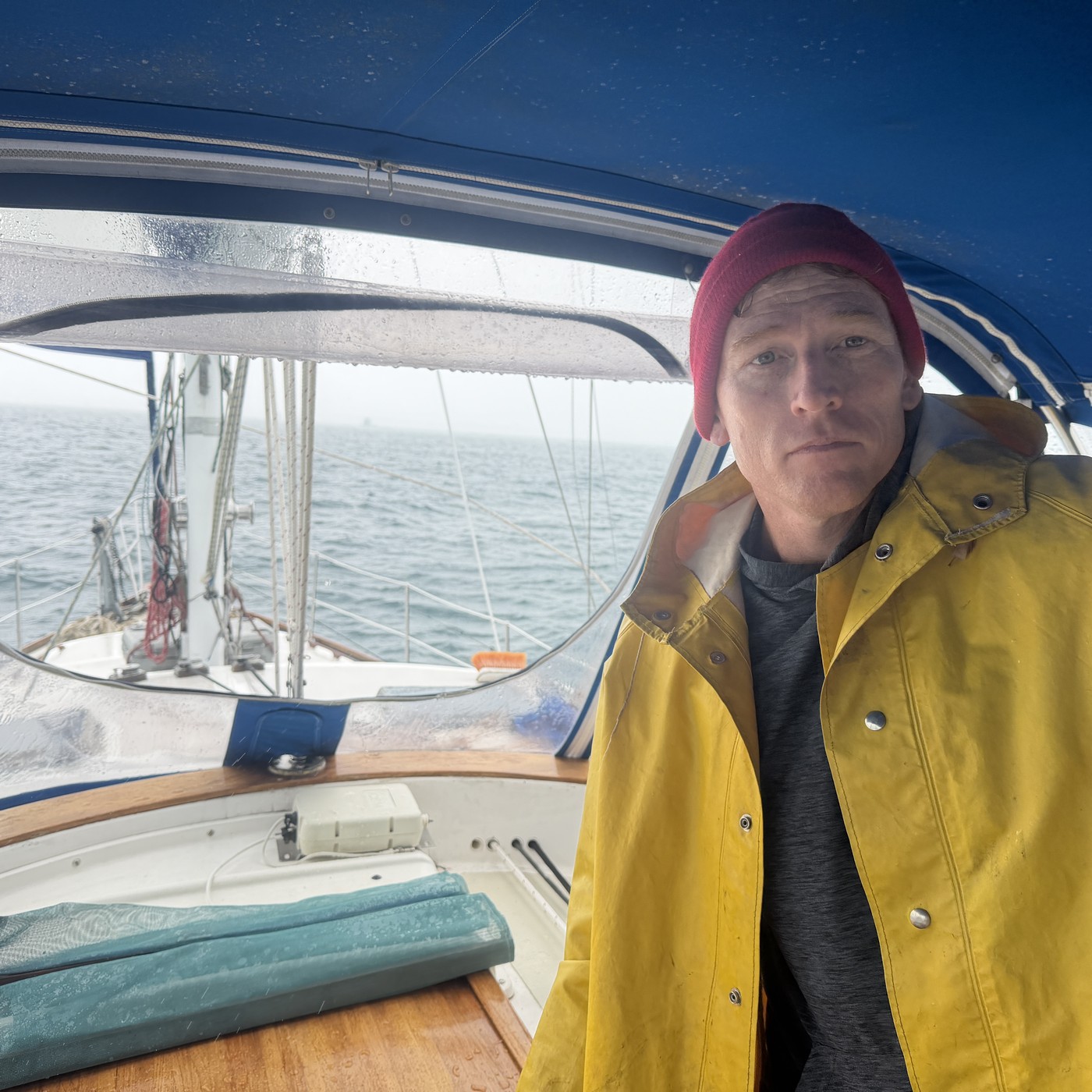 Jason at the helm in foul weather gear, underway