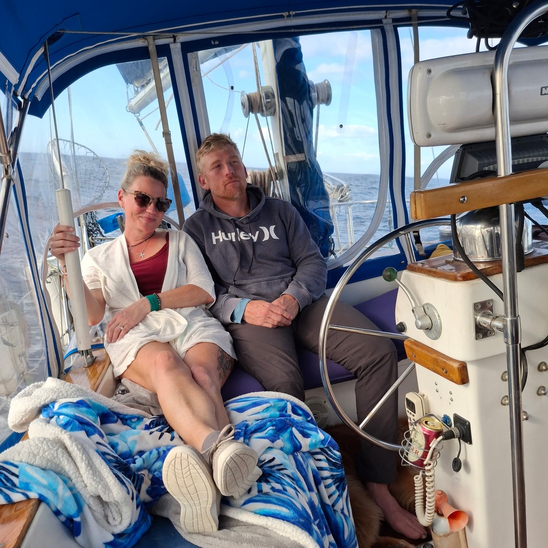 Jayme and Jason relaxing at the helm with Sunny at their feet