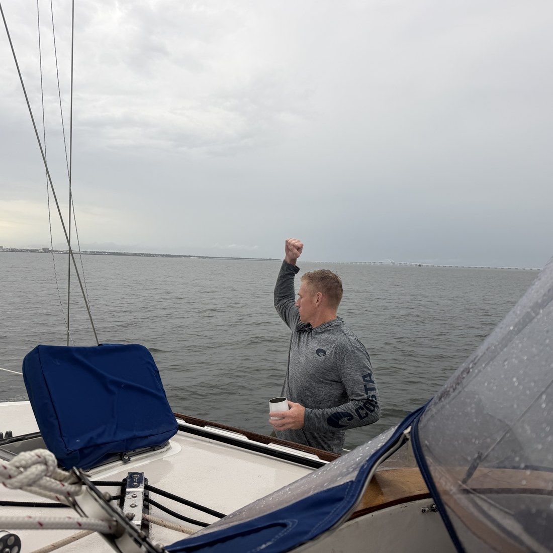 Jason celebrating on the foredeck under an overcast sky